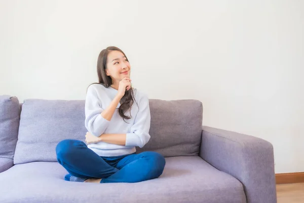 ポートレート美しい若いアジア人女性リラックス笑顔上のソファでリビングルーム — ストック写真
