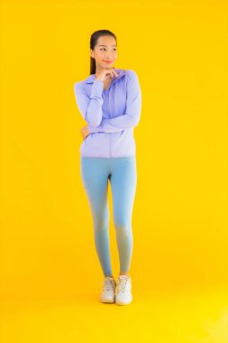 Sarı izole edilmiş arka planda spor giysili güzel Asyalı kadın portresi egzersize hazır.