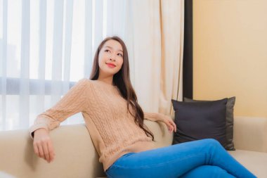 Güzel bir Asyalı kadın portresi rahatla. Gülümse. Yatak odasının iç dekorasyonunda mutlu ol.