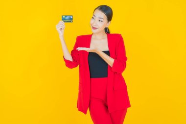 Güzel bir Asyalı kadının portresi. Renkli kredi kartıyla gülüyor.