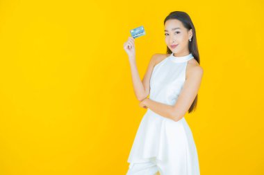 Güzel bir Asyalı kadının portresi. Renkli kredi kartıyla gülüyor.