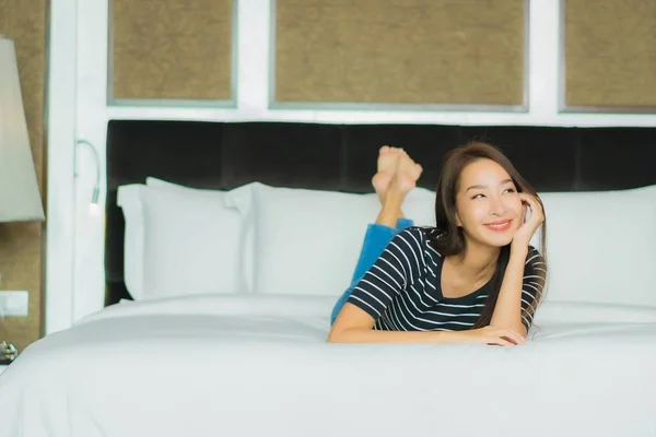 아름다운 아시아인 여인의 미소는 침실의 위에서 편안하게 흐른다 — 스톡 사진