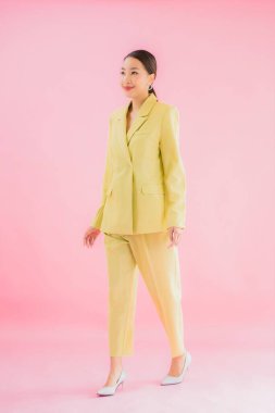 Portre güzel Asyalı genç iş kadını pembe arka planda gülümsüyor