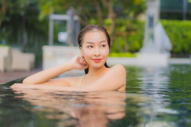 Güzel bir Asyalı kadın portresi. Rahatlayın. Yüzme havuzu etrafında gülümseyin.