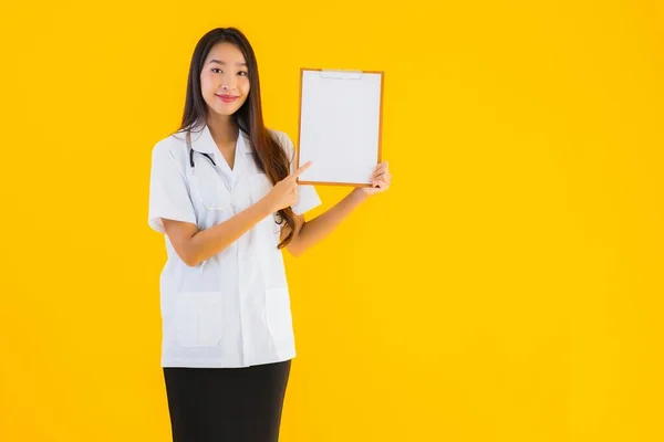 亚洲年轻貌美的女医生 背景为黄隔离 白板空旷 — 图库照片