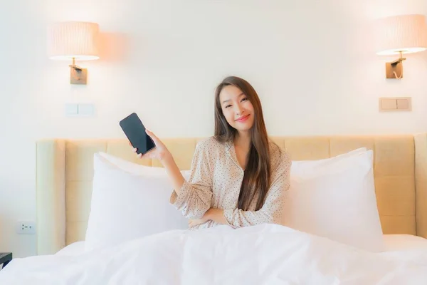Yatak Odasının Içinde Akıllı Cep Telefonu Olan Güzel Asyalı Bir — Stok fotoğraf