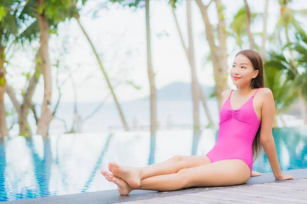 ポートレート美しい若いアジアの女性の笑顔休暇旅行でリゾートホテルの屋外スイミングプールの周りにリラックス — ストック写真