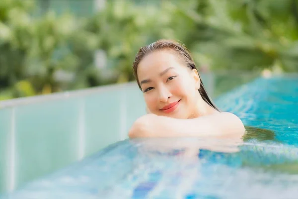 ポートレート美しい若いアジアの女性は休暇旅行で屋外スイミングプールの周りの笑顔のレジャーをリラックス — ストック写真