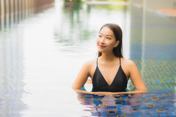 美丽动人的年轻亚洲女人笑着在酒店度假胜地的游泳池边放松休闲 — 图库照片