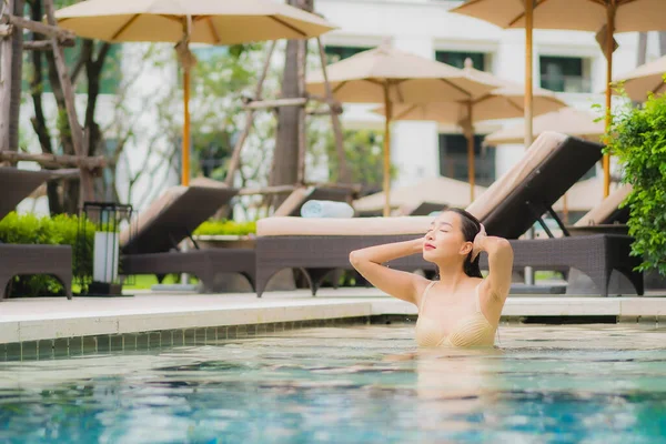 美しい若いアジアの女性の肖像旅行休暇のためのホテルのリゾートで屋外スイミングプールの周りの笑顔をリラックス — ストック写真