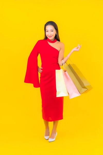 Sarı Arka Planda Alışveriş Çantası Kredi Kartıyla Güzel Bir Asyalı — Stok fotoğraf