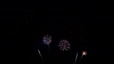 Gece gökyüzünde patlayan havai fişeklerin yakın çekim görüntüleri.
