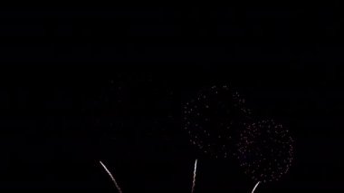 Gece gökyüzünde patlayan havai fişeklerin yakın çekim görüntüleri.