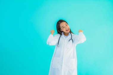 Klinikte ya da mavi izole edilmiş arka planda hastanede kullanmak üzere steteskoplu güzel Asyalı genç doktor kadın portresi.