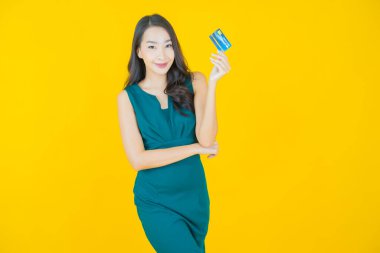 Güzel bir Asyalı kadının portresi. Renkli kredi kartıyla gülüyor.