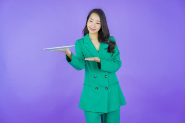 Güzel Asyalı bir kadının portresi. Arka planda boş tabak tabağıyla gülümsüyor.