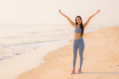 Portre sporu genç Asyalı kadın egzersiz hazırlıyor ya da sağlık için okyanusta koşuyor.