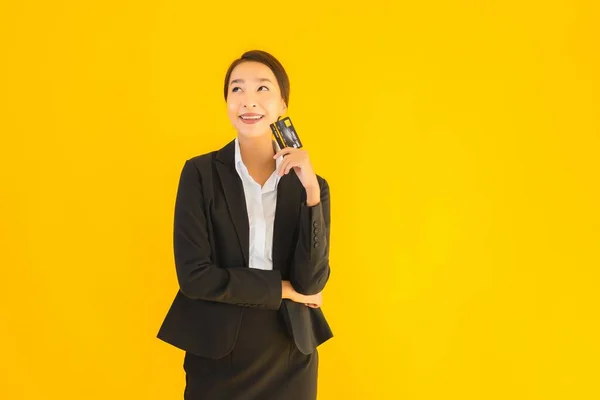 形象漂亮的年轻亚洲商人女子 背景黄色孤立 有信用卡 — 图库照片