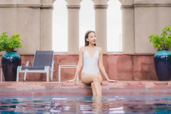 美丽动人的年轻亚洲女人在酒店和度假胜地的室外游泳池边悠闲地笑着 — 图库照片