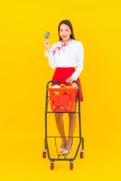 Portrét Krásná Mladá Asijská Žena Nákupním Košíkem Supermarketu Žlutém Pozadí — Stock fotografie