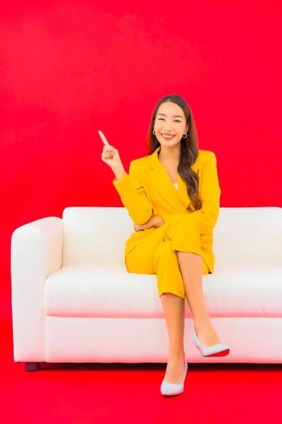 Güzel Bir Asyalı Kadın Portresi Kırmızı Arka Planda Koltukta Oturuyor — Stok fotoğraf