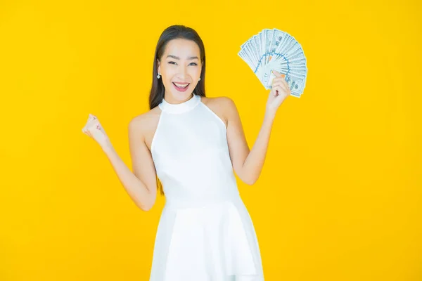 亚洲年轻貌美的女人面带微笑 带着大量的现金和金钱的色彩背景 — 图库照片