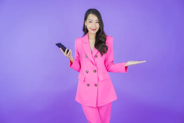 Renkli Arka Planda Akıllı Cep Telefonuyla Güzel Asyalı Kadın Gülümsemesi — Stok fotoğraf