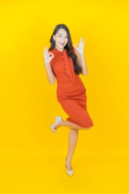 Portre güzel Asyalı kadın gülümsüyor. Renkli arka planda hareket var.