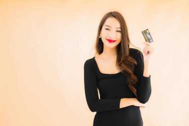 Renkli arka planda alışveriş yapmak için kredi kartı olan güzel bir Asyalı kadın portresi.