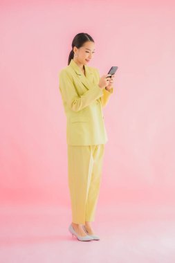 Güzel Asyalı iş kadını portresi. Arka planda kahve fincanı ve akıllı cep telefonu kullanıyor.