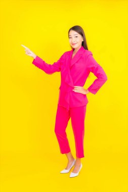 Güzel bir Asyalı kadın sarı arka planda gülümsüyor.