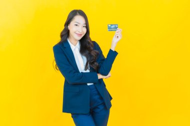 Güzel bir Asyalı kadının portresi. Renkli kredi kartıyla gülüyor.