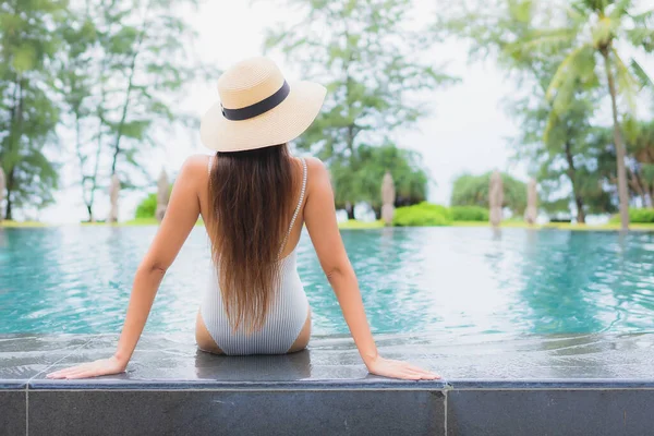 美丽动人的年轻亚洲女人在酒店度假胜地近岸海滩的室外游泳池边悠闲自在地笑着 — 图库照片