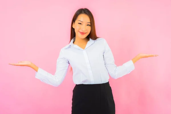 Portrait beautiful young business asian woman with action pink isolated background