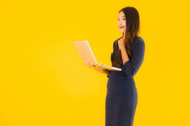 Bilgisayarı ya da bilgisayarı sarı izole edilmiş güzel Asyalı kadın portresi.