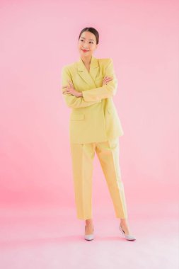 Portre güzel Asyalı genç iş kadını pembe arka planda gülümsüyor