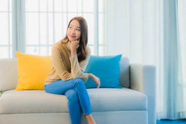 Güzel bir Asyalı kadın portresi. Rahat ol. Oturma odasının iç kısmındaki kanepede keyfine bak.