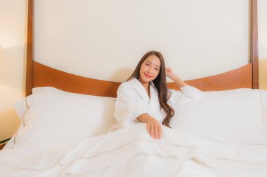 Güzel bir Asyalı kadının portresi. Gülümse. Yatak odasında rahatla.