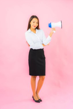 Pembe arka planda megafonu olan güzel Asyalı kadın portresi.