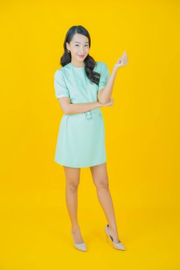 Portre güzel Asyalı kadın gülümsüyor. Renkli arka planda hareket var.