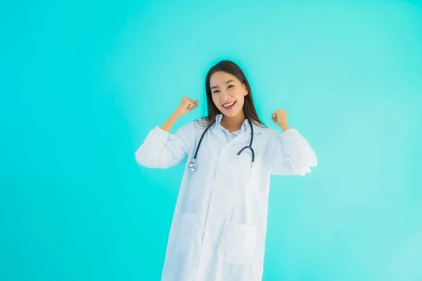 ポートレート美しいです若いですアジアの医師女性とともにStethoscope用のクリニックや病院での使用上の青隔離された背景 — ストック写真