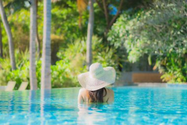 Güzel bir Asyalı kadın portresi. Mutlu bir gülümseme. Keyifli bir tatil için otel havuzunda rahatça yüzme havuzu.
