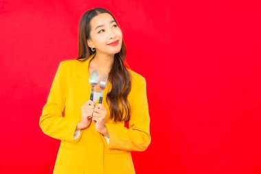 Kırmızı arka planda çatal ve kaşıkla güzel bir iş kadını portresi.