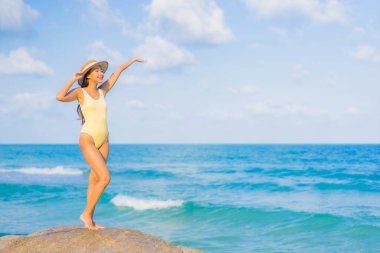 Güzel bir Asyalı kadının portresi. Rahatlayın. Plaj okyanusunda tatil yaparken gülümseyin.