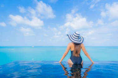 Güzel bir Asyalı kadın portresi. Rahatlayın. Okyanus manzaralı, tatil köyündeki yüzme havuzunda rahatlayın.