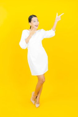 Portre güzel Asyalı kadın gülümsüyor. Renkli arka planda hareket var.