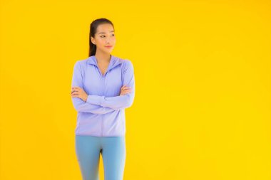 Sarı izole edilmiş arka planda spor giysili güzel Asyalı kadın portresi egzersize hazır.