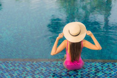 Güzel bir Asyalı kadın portresi. Tatil tatilinde açık havada yüzme havuzunun keyfini çıkar.