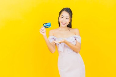 Güzel bir Asyalı kadının portresi. Renkli kredi kartıyla gülüyor.