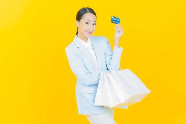 Portre güzel Asyalı kadın tebessümü ile renk arka planında alışveriş torbası